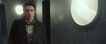 Movie still from “Lucky Number Slevin” (2006), directed by Paul McGuigan – A man in a suit and tie standing in front of a mirror; Medium shot, Over the shoulder angle
