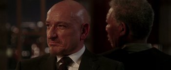 Movie still from “Lucky Number Slevin” (2006), directed by Paul McGuigan – A man in a suit and tie next to an older man in a suit and tie; Close Up shot, Over the shoulder angle