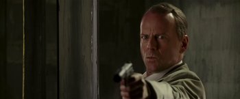 Movie still from “Lucky Number Slevin” (2006), directed by Paul McGuigan – A man holding a gun in his hand; Close Up shot, Low angle