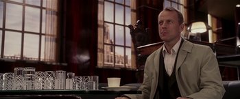 Movie still from “Lucky Number Slevin” (2006), directed by Paul McGuigan – A man sitting at a table in front of a window; Medium shot, Over the shoulder angle