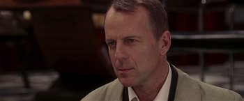 Movie still from “Lucky Number Slevin” (2006), directed by Paul McGuigan – A person wearing a suit and tie; Close Up shot, Over the shoulder angle