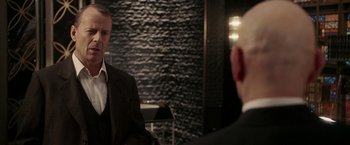 Movie still from “Lucky Number Slevin” (2006), directed by Paul McGuigan – A man in a suit and tie in front of a mirror; Medium shot, Over the shoulder angle