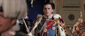Movie still from “Ludwig” (1973), directed by Luchino Visconti – A man in a military uniform holding a sword in his hand; Medium shot, Low angle