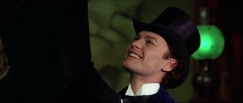 Movie still from “Ludwig” (1973), directed by Luchino Visconti – A man wearing a black top hat and a black tie; Close Up shot, Low angle