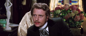 Movie still from “Ludwig” (1973), directed by Luchino Visconti – A person wearing a suit and a tie; Close Up shot, Over the shoulder angle