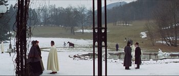 Movie still from “Ludwig” (1973), directed by Luchino Visconti – A group of people standing in a field with horses; Extreme Wide shot, Over the shoulder angle