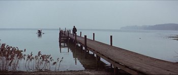 Movie still from “Ludwig” (1973), directed by Luchino Visconti – A person standing on a pier near a body of water; Extreme Wide shot, High angle