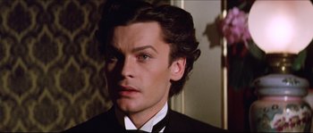 Movie still from “Ludwig” (1973), directed by Luchino Visconti – A person wearing a suit and tie; Close Up shot, High angle