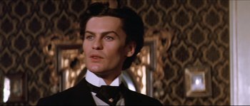 Movie still from “Ludwig” (1973), directed by Luchino Visconti – A person wearing a suit and tie; Close Up shot, Low angle