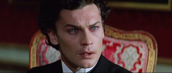 Movie still from “Ludwig” (1973), directed by Luchino Visconti – A person wearing a suit and tie; Close Up shot, High angle