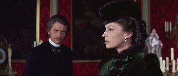 Movie still from “Ludwig” (1973), directed by Luchino Visconti – A man and a woman standing next to each other in a room; Close Up shot, Over the shoulder angle