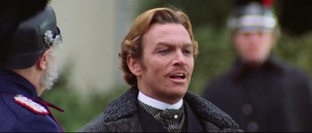 Movie still from “Ludwig” (1973), directed by Luchino Visconti – A person wearing a suit and tie; Close Up shot, Over the shoulder angle