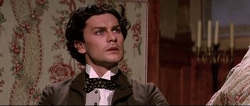 Movie still from “Ludwig” (1973), directed by Luchino Visconti – A person wearing a suit and a bow tie; Close Up shot, Low angle