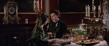 Movie still from “Ludwig” (1973), directed by Luchino Visconti – A man and a woman sitting at a dinner table; Medium shot, High angle