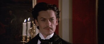 Movie still from “Ludwig” (1973), directed by Luchino Visconti – A person wearing a suit and tie; Close Up shot, High angle