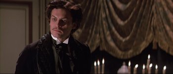 Movie still from “Ludwig” (1973), directed by Luchino Visconti – A person wearing a suit and tie; Close Up shot, Low angle