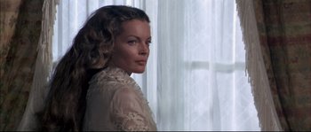Movie still from “Ludwig” (1973), directed by Luchino Visconti – A woman in a white dress standing in front of a window; Close Up shot, Low angle