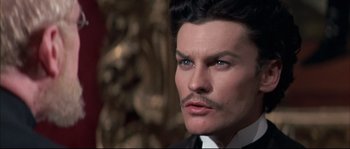Movie still from “Ludwig” (1973), directed by Luchino Visconti – A person wearing a suit and tie; Close Up shot, Low angle