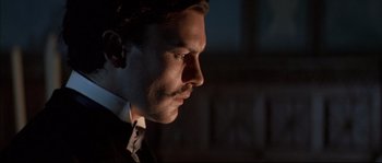 Movie still from “Ludwig” (1973), directed by Luchino Visconti – A person wearing a suit and tie; Close Up shot, Low angle