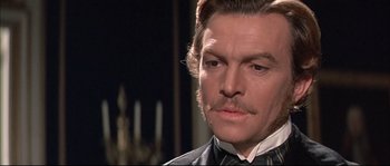 Movie still from “Ludwig” (1973), directed by Luchino Visconti – A person wearing a suit and tie; Close Up shot, Over the shoulder angle