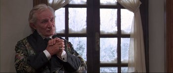 Movie still from “Ludwig” (1973), directed by Luchino Visconti – An older man sitting in front of a window; Medium shot, Low angle