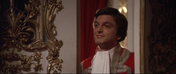 Movie still from “Ludwig” (1973), directed by Luchino Visconti – A man in a red and white jacket standing in front of a mirror; Close Up shot, Over the shoulder angle