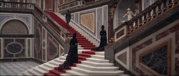 Movie still from “Ludwig” (1973), directed by Luchino Visconti – Two women dressed in black are walking down the stairs; Extreme Wide shot, High angle