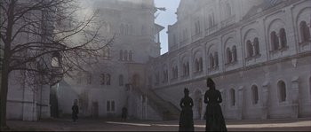 Movie still from “Ludwig” (1973), directed by Luchino Visconti – Two women dressed in period clothing standing in front of a building; Extreme Wide shot, Low angle