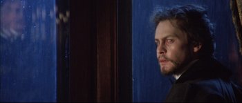 Movie still from “Ludwig” (1973), directed by Luchino Visconti – A person wearing a suit and tie; Close Up shot, Over the shoulder angle