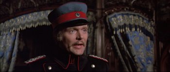 Movie still from “Ludwig” (1973), directed by Luchino Visconti – A man in a military uniform wearing a red hat; Close Up shot, High angle