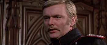 Movie still from “Ludwig” (1973), directed by Luchino Visconti – A man with long hair and a mustache; Close Up shot, Over the shoulder angle
