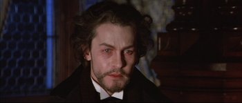 Movie still from “Ludwig” (1973), directed by Luchino Visconti – A person wearing a suit and tie; Close Up shot, High angle