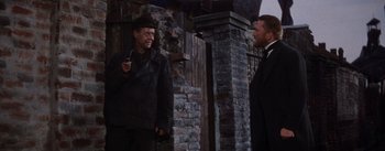 Movie still from “Lust for Life” (1956), directed by George Cukor – Two men are standing in front of a brick wall; Medium shot, Low angle