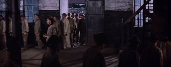 Movie still from “Lust for Life” (1956), directed by George Cukor – A group of men standing next to each other in front of a building; Wide shot, High angle