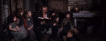 Movie still from “Lust for Life” (1956), directed by George Cukor – An old man reading a book to a group of children; Medium shot, High angle