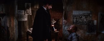 Movie still from “Lust for Life” (1956), directed by George Cukor – A man in a suit and hat talking to another man in a suit and hat; Medium shot, Over the shoulder angle