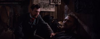 Movie still from “Lust for Life” (1956), directed by George Cukor – Two men sitting on a couch in front of a wall; Medium shot, Over the shoulder angle