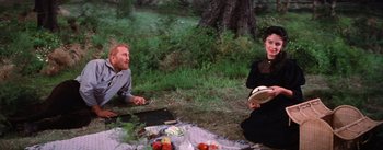 Movie still from “Lust for Life” (1956), directed by George Cukor – A man and a woman sitting on the ground in the woods; Medium shot, High angle