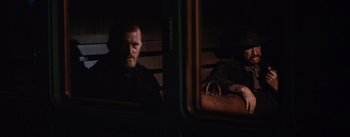 Movie still from “Lust for Life” (1956), directed by George Cukor – A man sitting in a train with a bag in front of him; Medium shot, Over the shoulder angle