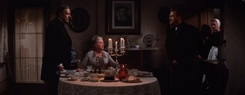 Movie still from “Lust for Life” (1956), directed by George Cukor – An older woman sitting at a dinner table with candles; Wide shot, Over the shoulder angle