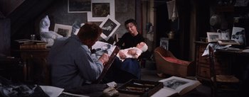 Movie still from “Lust for Life” (1956), directed by George Cukor – A man holding a baby while a woman watches; Medium shot, High angle