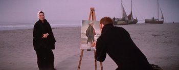 Movie still from “Lust for Life” (1956), directed by George Cukor – A man is painting a picture on the easel on the beach; Medium shot, Over the shoulder angle