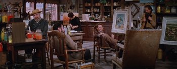 Movie still from “Lust for Life” (1956), directed by George Cukor – A man sitting in a chair next to a woman; Wide shot, Low angle