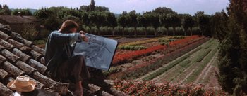 A woman sitting on a bench in a flower garden