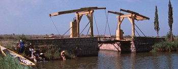 Movie still from “Lust for Life” (1956), directed by George Cukor – Two people in a body of water near a bridge; Extreme Wide shot, Low angle