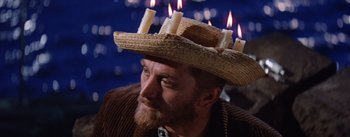 Movie still from “Lust for Life” (1956), directed by George Cukor – A man wearing a hat with candles on top of his head; Close Up shot, Low angle