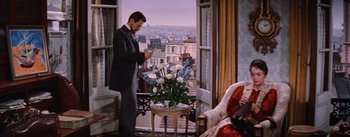 Movie still from “Lust for Life” (1956), directed by George Cukor – A man standing in front of a window looking at flowers in a vase; Wide shot, High angle