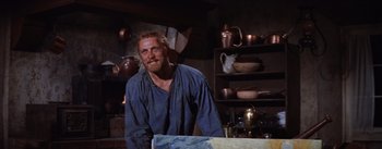 Movie still from “Lust for Life” (1956), directed by George Cukor – A man standing in front of a table in a room; Medium shot, Low angle