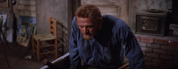 Movie still from “Lust for Life” (1956), directed by George Cukor – A man in a blue shirt is looking down; Medium shot, Low angle