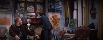 Movie still from “Lust for Life” (1956), directed by George Cukor – A woman standing in front of a chair in a room filled with paintings; Medium shot, Over the shoulder angle